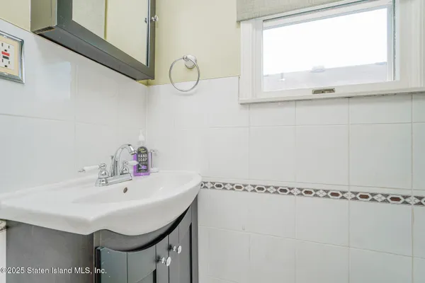 a bathroom with a sink a mirror and a window