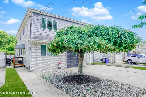 a yellow house with trees in front of it
