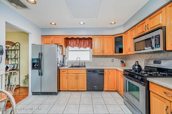 a kitchen with stainless steel appliances granite countertop a refrigerator and a stove top oven