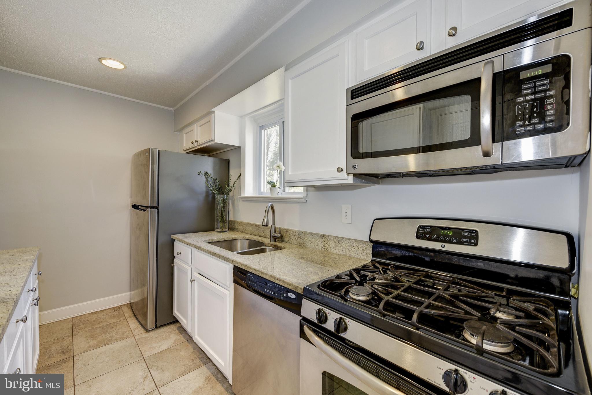 2802 Harris Avenue Silver Spring, MD 20902 - Photo 14 of 43 a kitchen with stainless steel appliances granite countertop a stove and a microwave