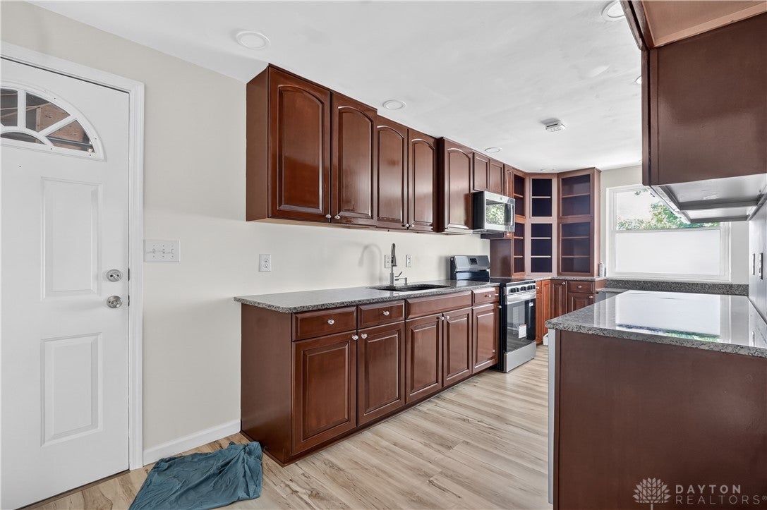 1243 Student Avenue Springfield, OH 45503 - Photo 13 of 38 Rich wood cabinetry paired with granite countertops defines this functional kitchen space.