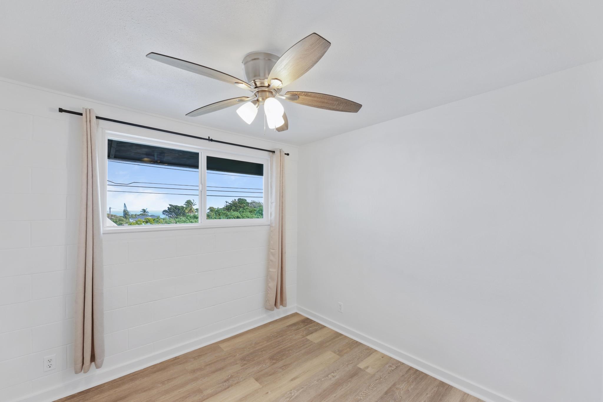 6 Kahope Place Haiku, HI 96708 - Photo 21 of 49 an empty room with wooden floor chandelier fan and windows