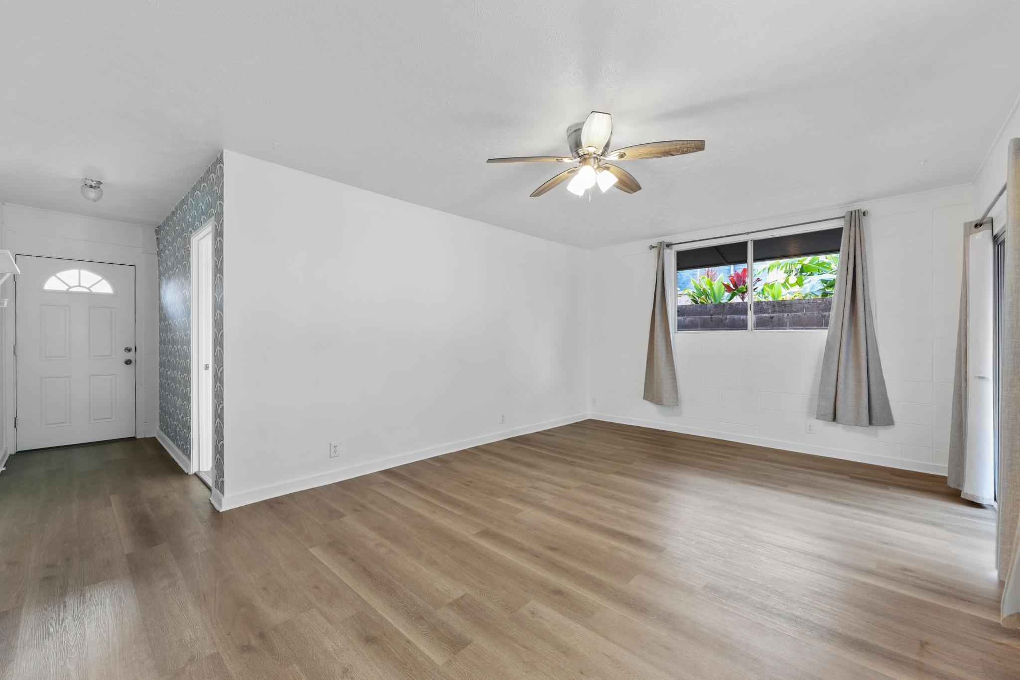 6 Kahope Place Haiku, HI 96708 - Photo 23 of 49 an empty room with wooden floor chandelier fan and windows