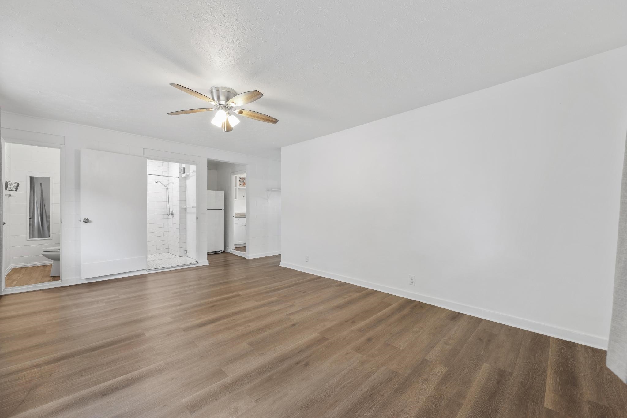 6 Kahope Place Haiku, HI 96708 - Photo 27 of 49 a view of an empty room with chandelier fan and wooden floor