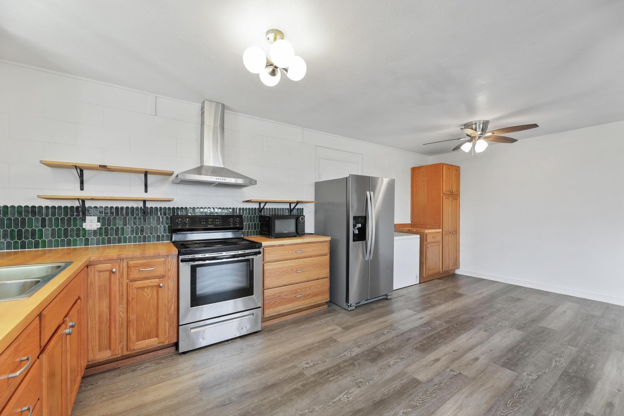 6 Kahope Place Haiku, HI 96708 - Photo 7 of 49 a kitchen with stainless steel appliances granite countertop a sink a stove a refrigerator cabinets and wooden floor