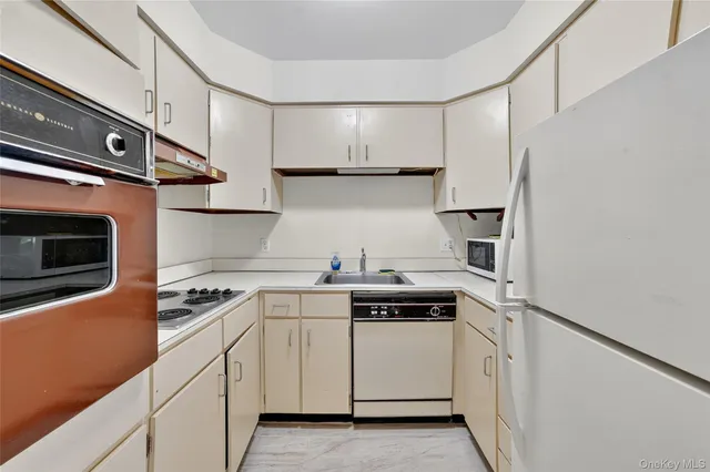 a kitchen with white cabinets and white appliances