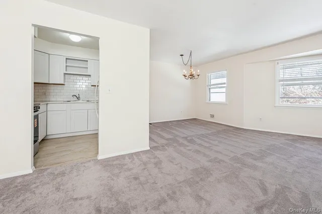 an empty room with windows and cabinet