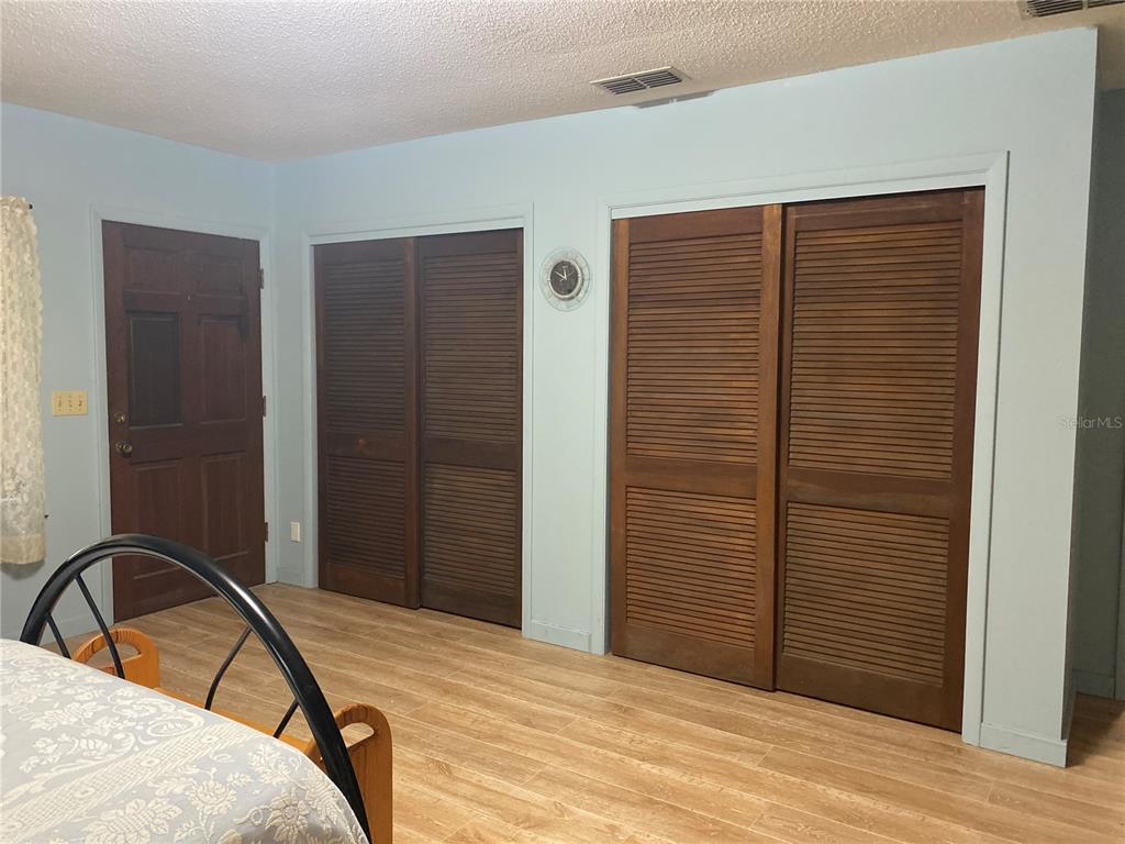 8093 Breezy Point Road East Keystone Heights, FL 32656 - Photo 12 of 34 a bedroom with a bed and a dresser