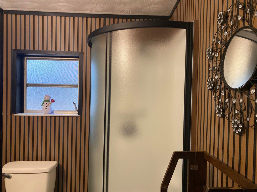 8093 Breezy Point Road East Keystone Heights, FL 32656 - Photo 19 of 34 a view of a hallway with wooden floor and a bathroom