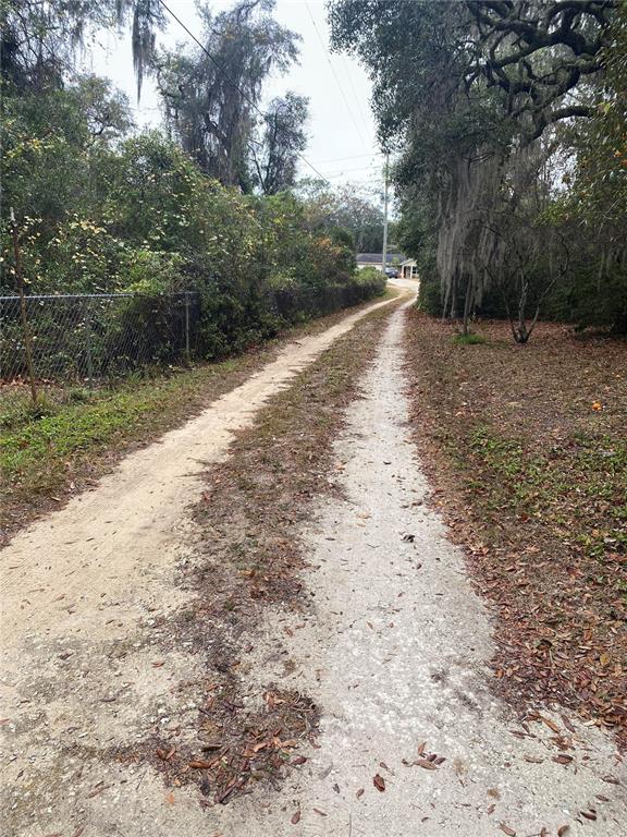 8093 Breezy Point Road East Keystone Heights, FL 32656 - Photo 22 of 34 a view of a dirt road with trees in the background