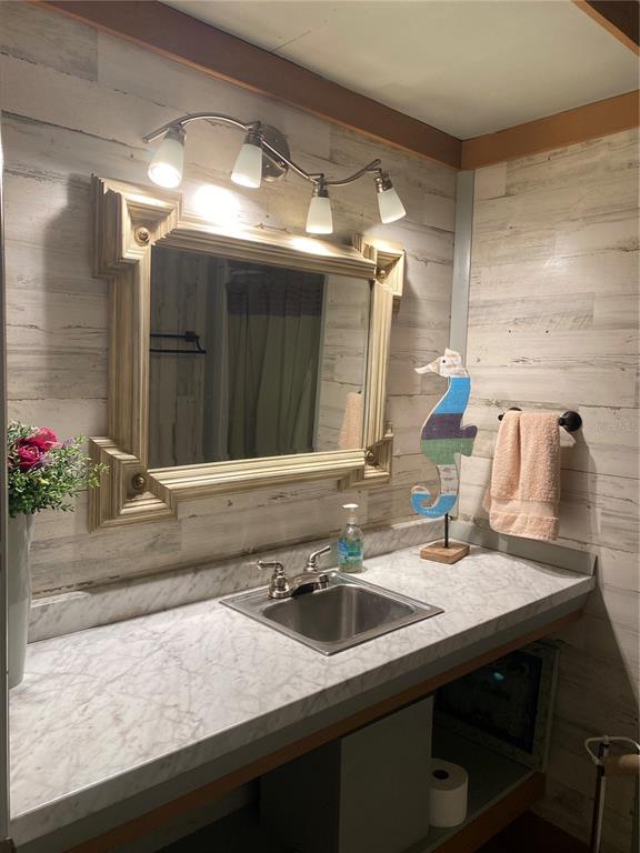 8093 Breezy Point Road East Keystone Heights, FL 32656 - Photo 28 of 34 a bathroom with a sink and a mirror