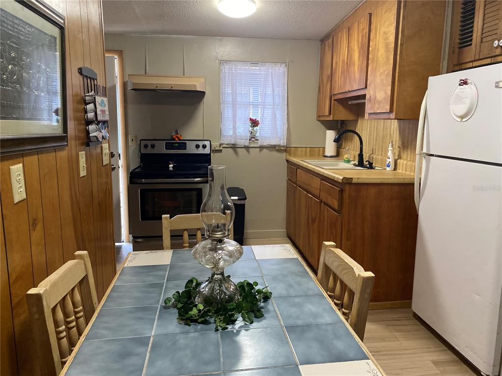 8093 Breezy Point Road East Keystone Heights, FL 32656 - Photo 9 of 34 a kitchen with a refrigerator and a stove