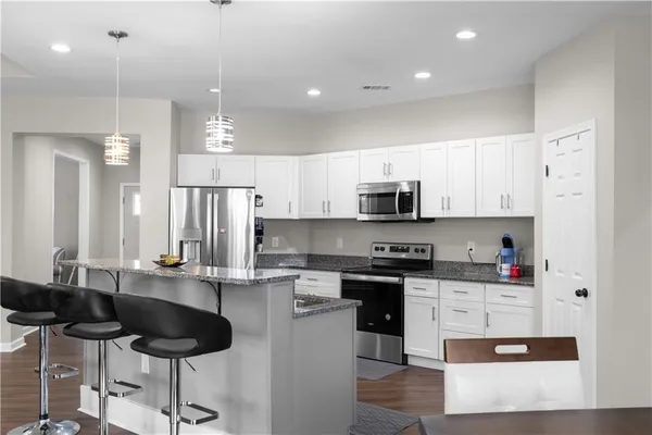 a kitchen with stainless steel appliances kitchen island granite countertop a sink and cabinets