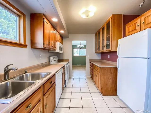 a kitchen with a sink a refrigerator and cabinets