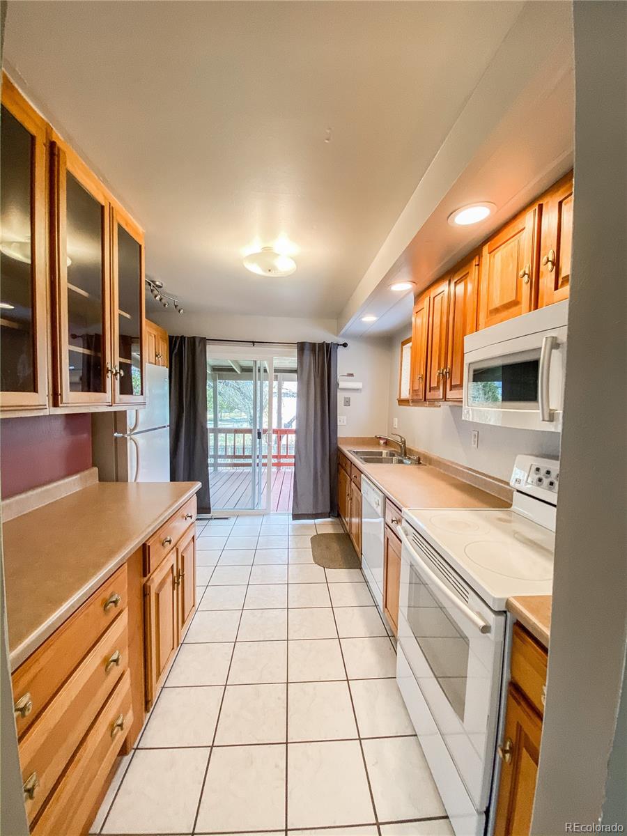 2214 Wold Avenue Colorado Springs, CO 80909 - Photo 15 of 38 a large kitchen with stainless steel appliances granite countertop a large stove top oven and cabinets