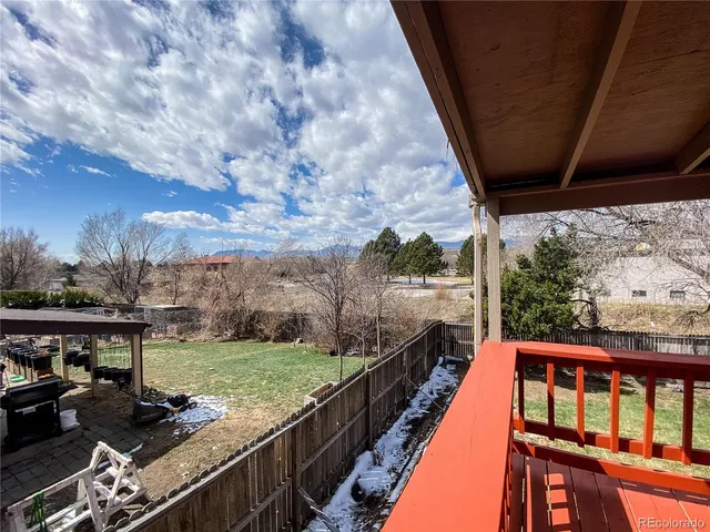 a balcony with wooden floor and outdoor seating