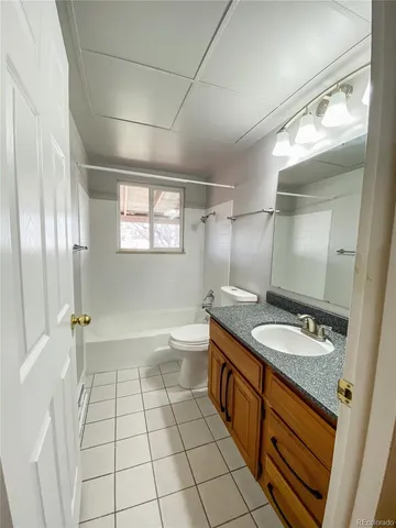 a spacious bathroom with a granite countertop sink a toilet a mirror and shower