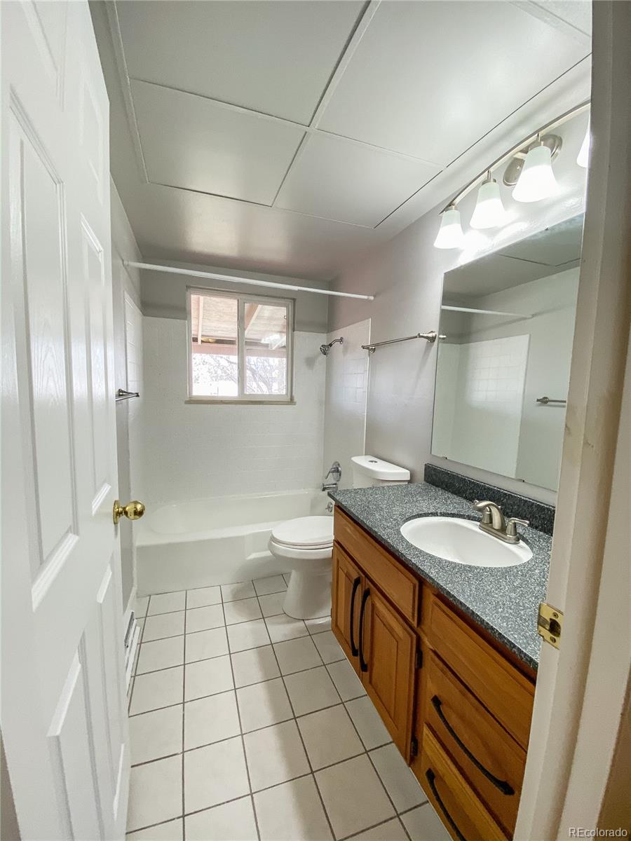 2214 Wold Avenue Colorado Springs, CO 80909 - Photo 24 of 38 a spacious bathroom with a granite countertop sink a toilet a mirror and shower