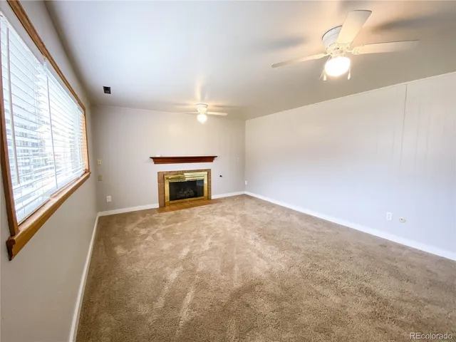 en empty room with windows and fireplace