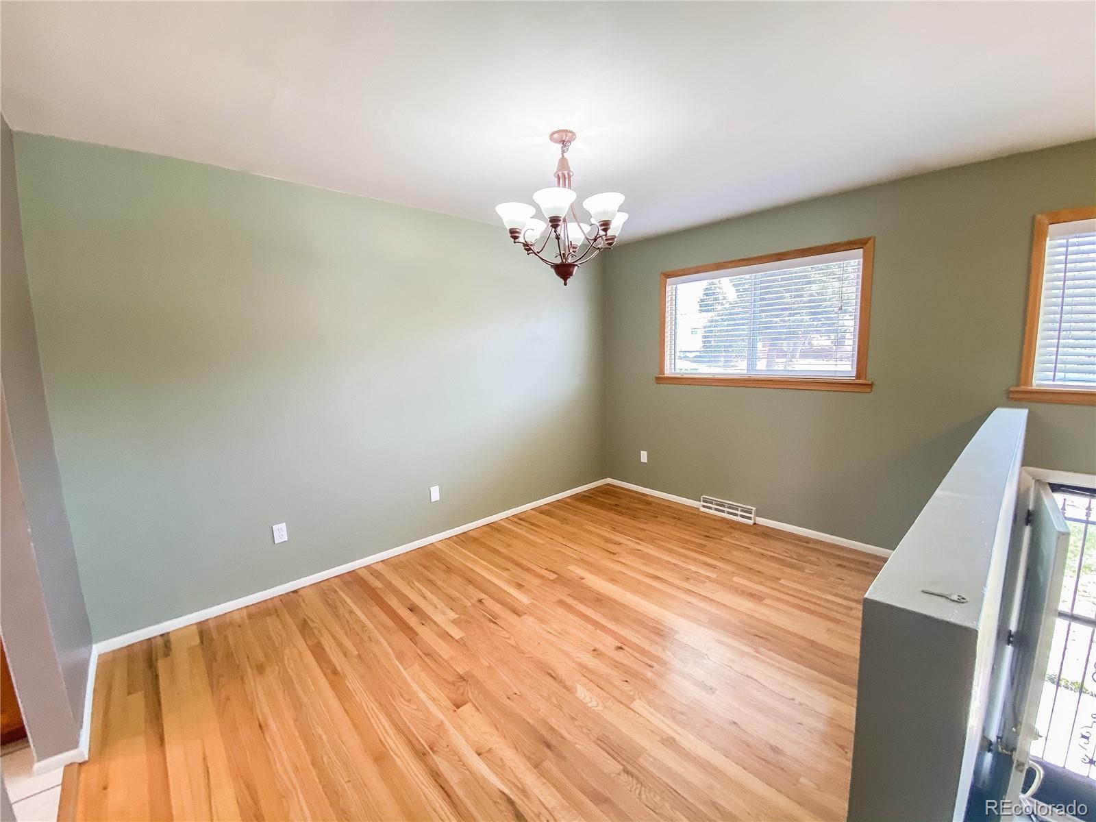 2214 Wold Avenue Colorado Springs, CO 80909 - Photo 4 of 38 a bedroom with a bed and a chandelier