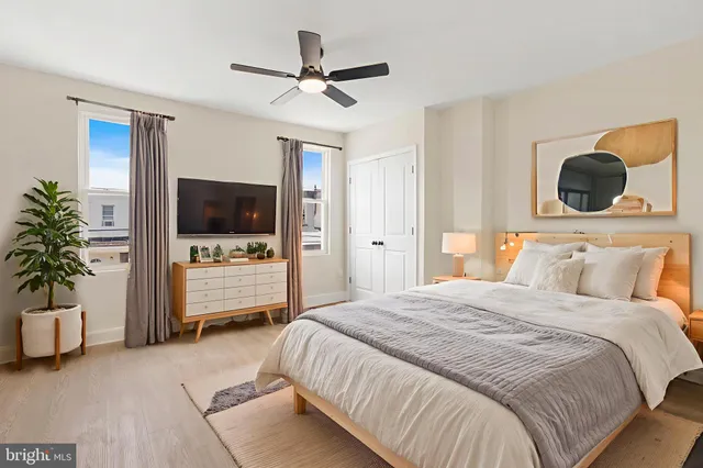 a bedroom with a bed a flat screen tv and a potted plant