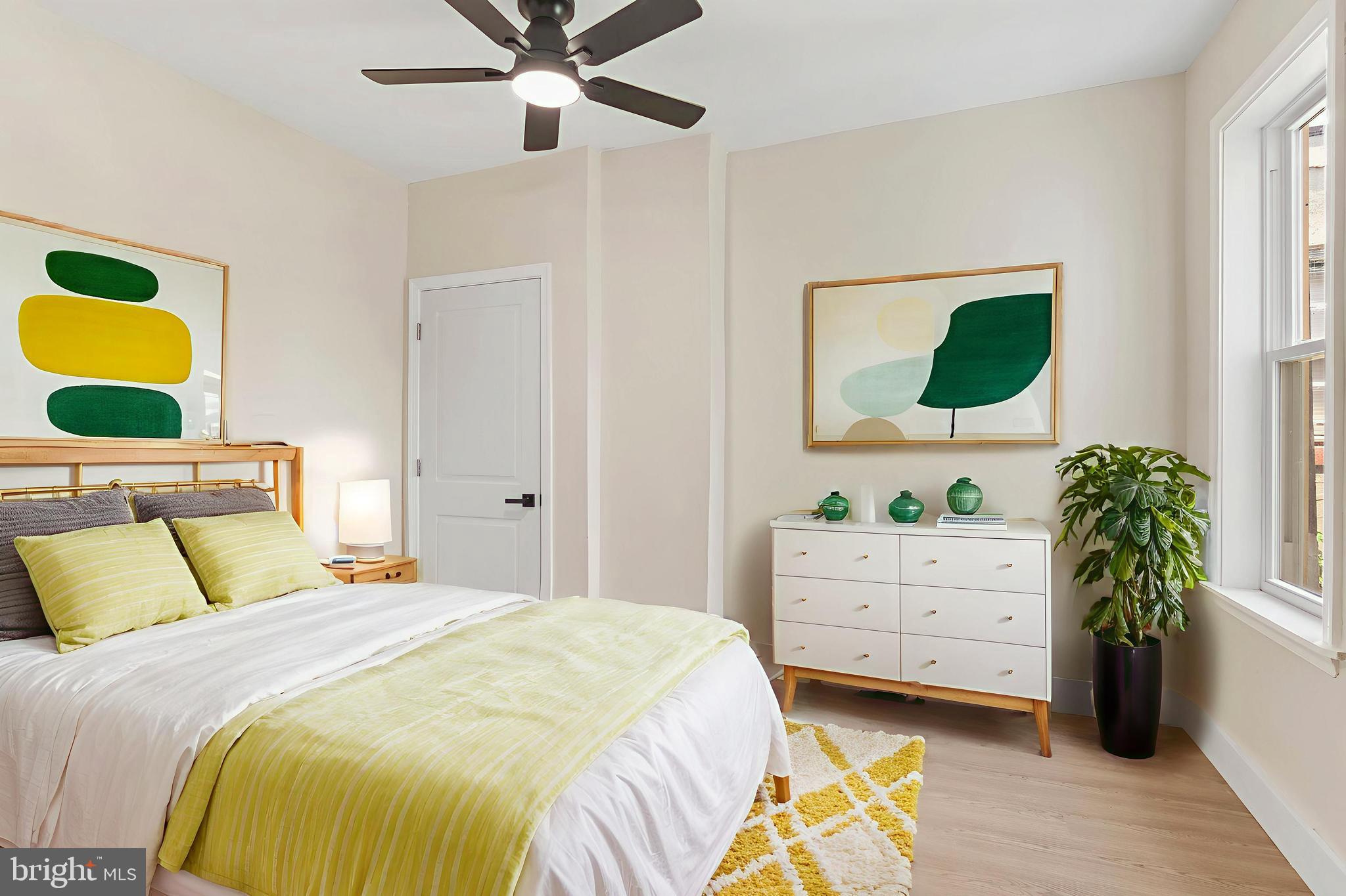 1221 North 50th Street Philadelphia, PA 19131 - Photo 16 of 24 a bedroom with a bed a dresser and a potted plant
