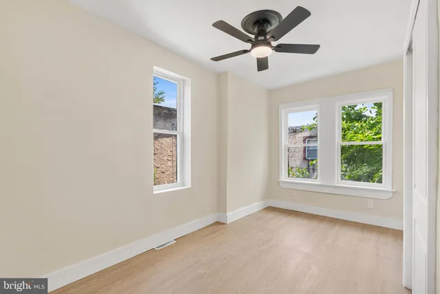 an empty room with window and ceiling fan