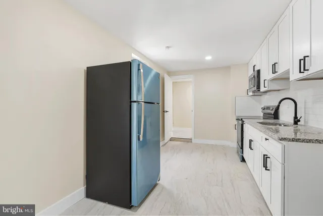 a kitchen with refrigerator and sink