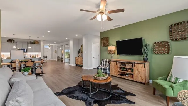 a living room with furniture flat screen tv and a large window