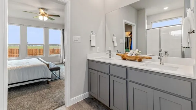 a bedroom with a bed and a lamp on dresser