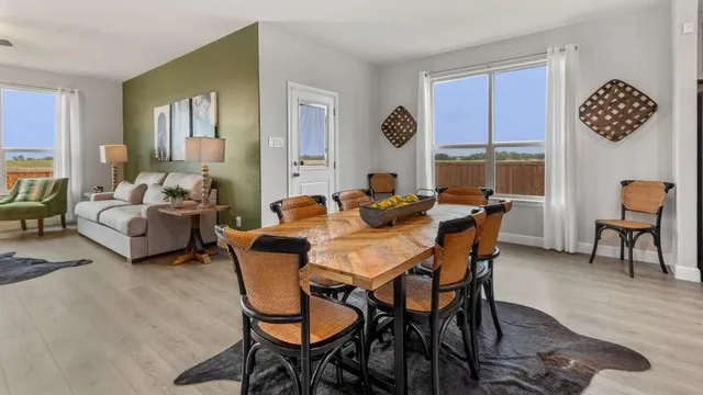 a dining room with kitchen island furniture a wooden floor and a sink