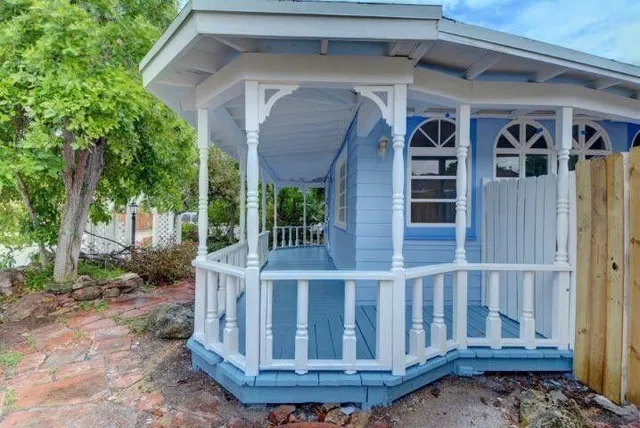 a view of wooden house with a small yard