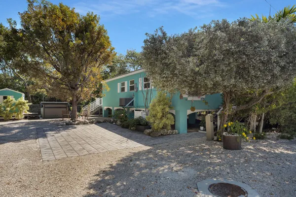 a view of a house with backyard and sitting area