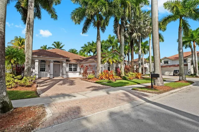 a view of the house with palm trees