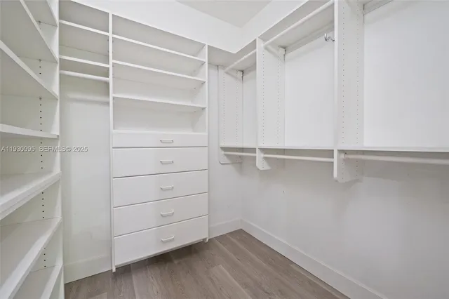 a view of walk in closet with empty racks