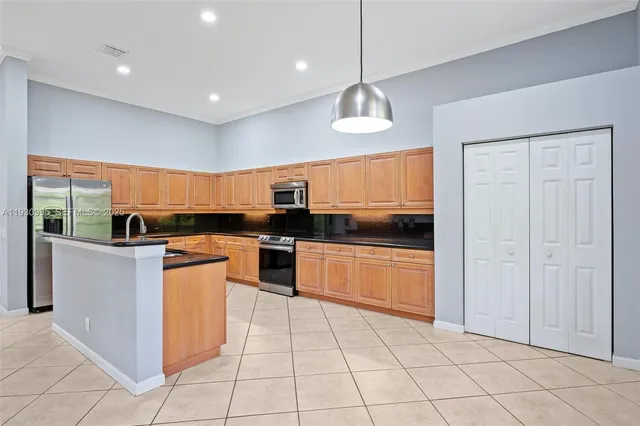 a large kitchen with stainless steel appliances granite countertop a stove and refrigerator