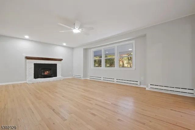 wooden floor fireplace and windows in an empty room
