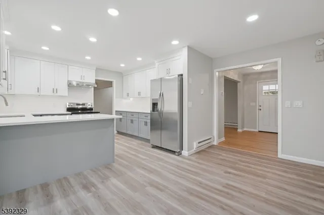 a kitchen with stainless steel appliances granite countertop a refrigerator and a stove top oven