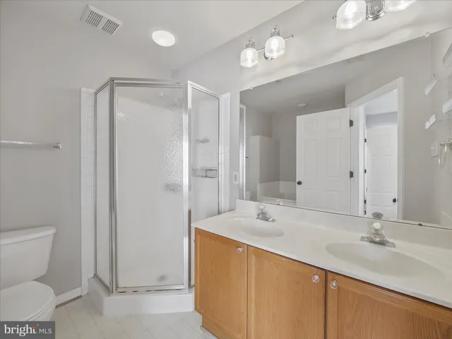 a bathroom with a double vanity sink mirror and toilet