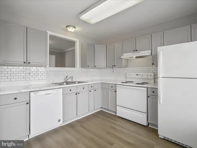 a kitchen with granite countertop white cabinets and white appliances