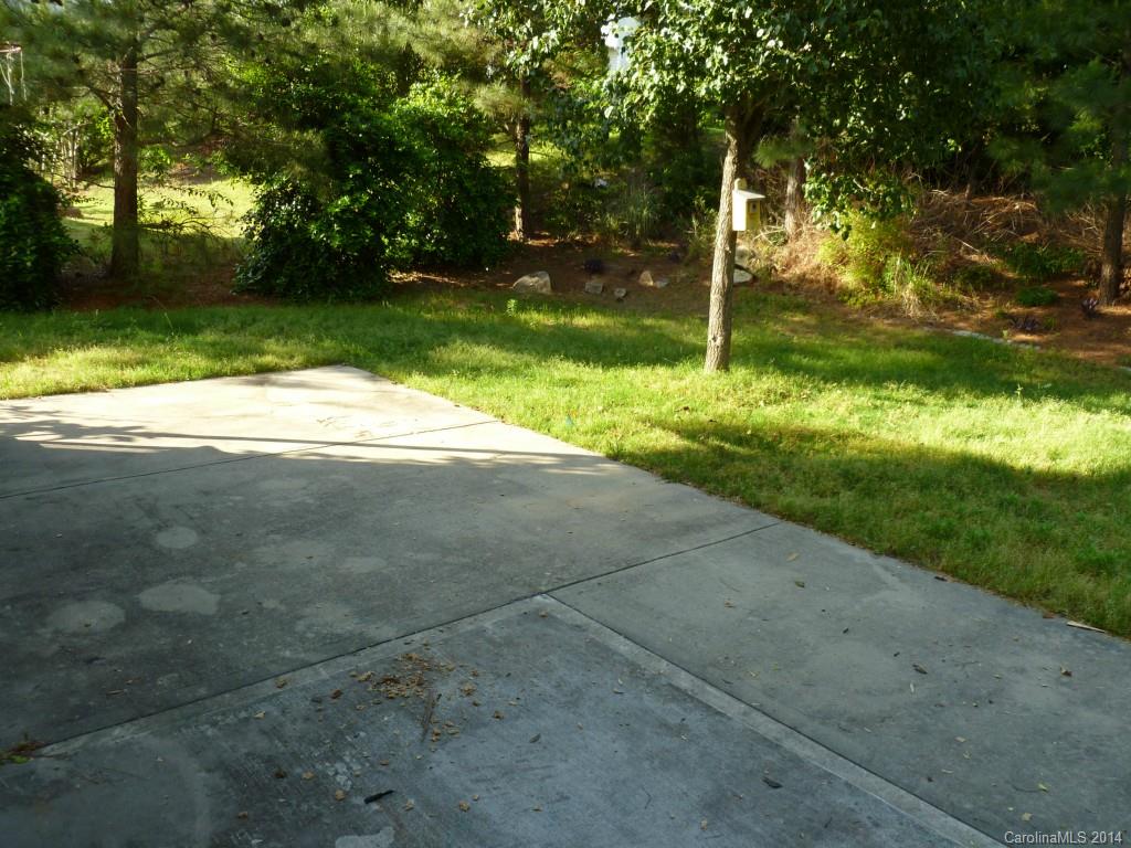 7629 Black Hawk Lane, Unit 43 Tega Cay, SC 29708 - Photo 14 of 18 a backyard of a house with plants and large trees
