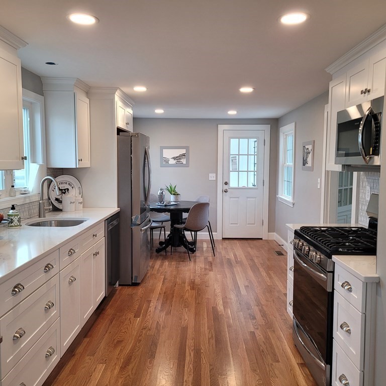 114 Conant Street Danvers, MA 01923 - Photo 7 of 29 a kitchen with sink stove and cabinets