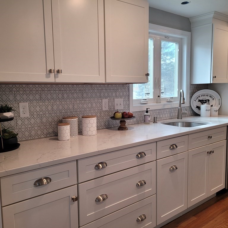 114 Conant Street Danvers, MA 01923 - Photo 9 of 29 a kitchen with white cabinets and sink