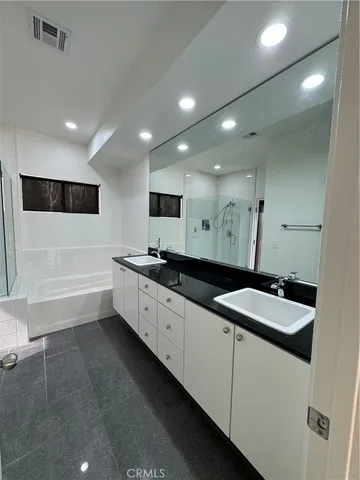 a bathroom with a granite countertop sink a toilet and a bathtub