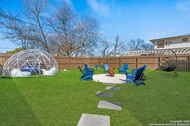 a bench sitting in the grass near a yard