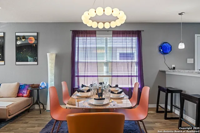 a view of a dining room with furniture a chandelier and wooden floor