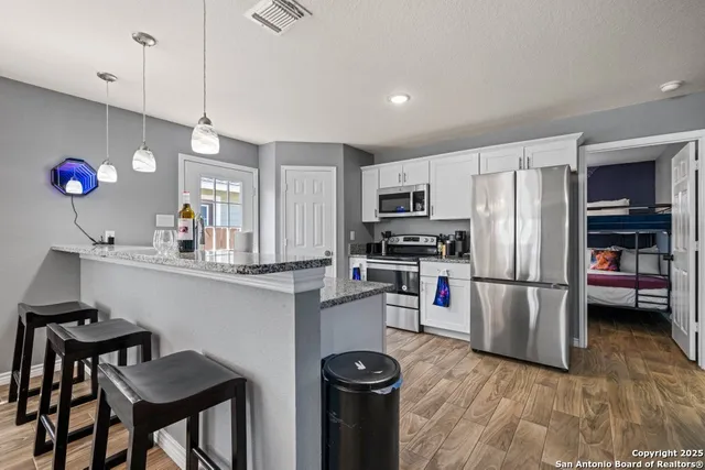 a kitchen with refrigerator a microwave a stove and cabinets
