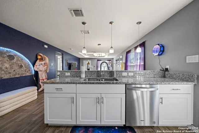 a kitchen with granite countertop a sink and cabinets