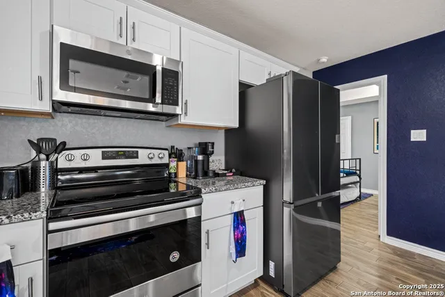 a kitchen with stainless steel appliances granite countertop a stove microwave and refrigerator