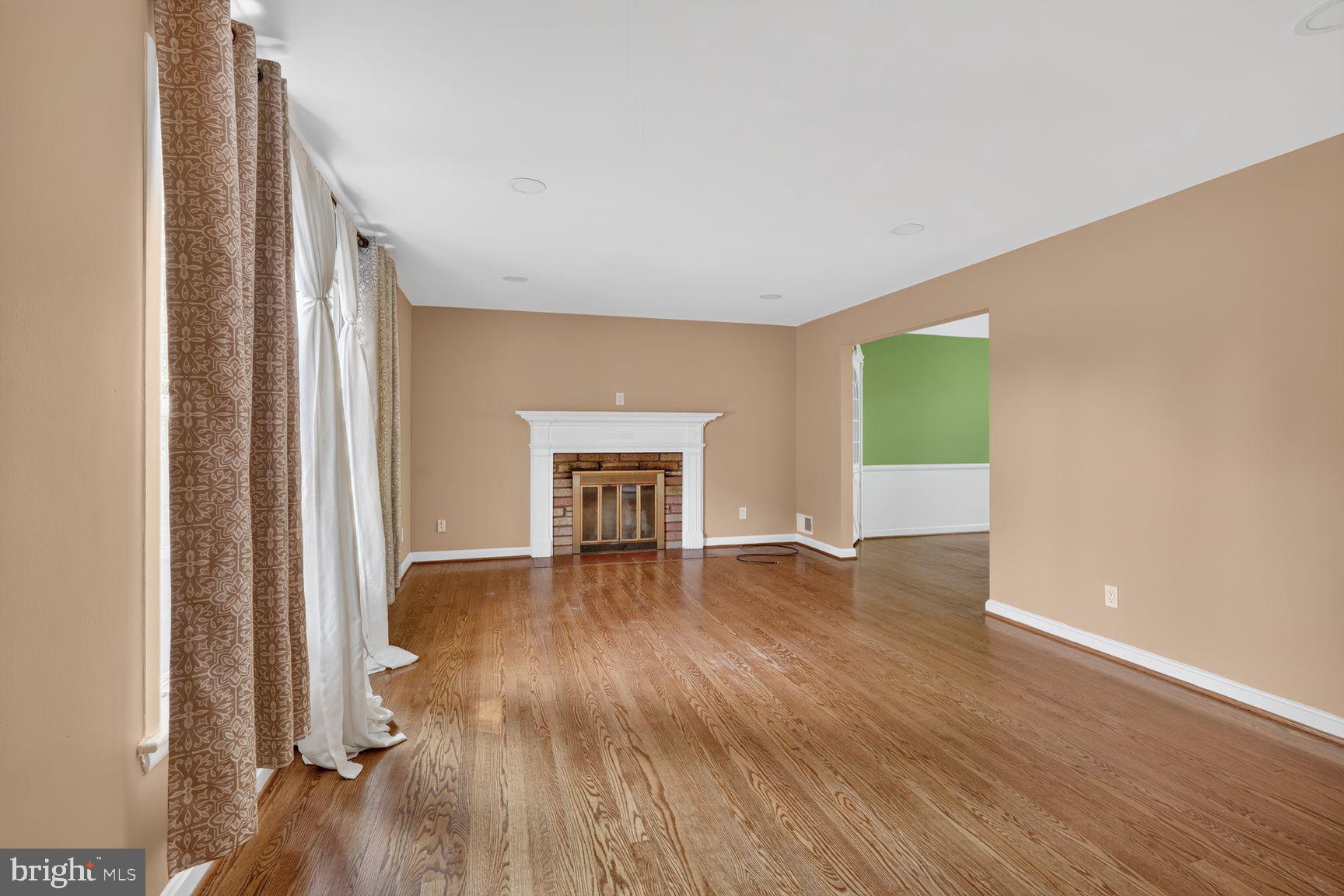3919 Chesterbrook Road Arlington, VA 22207 - Photo 5 of 26 an empty room with wooden floor and fireplace